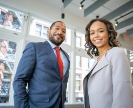 man and woman smiling inside building