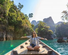 photo of woman sitting on boat spreading her arms