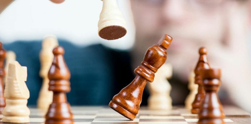 man holding chess piece