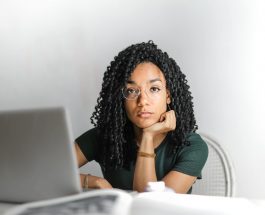 serious ethnic young woman using laptop at home