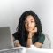 serious ethnic young woman using laptop at home