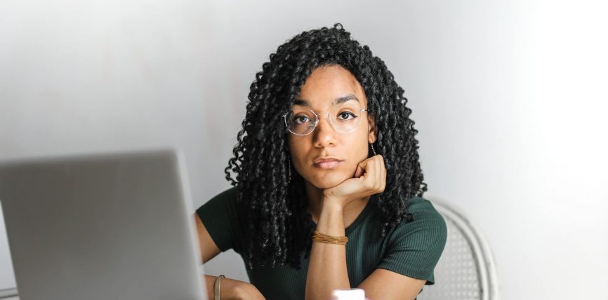 serious ethnic young woman using laptop at home