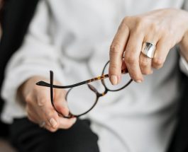 person holding brown framed eyeglasses